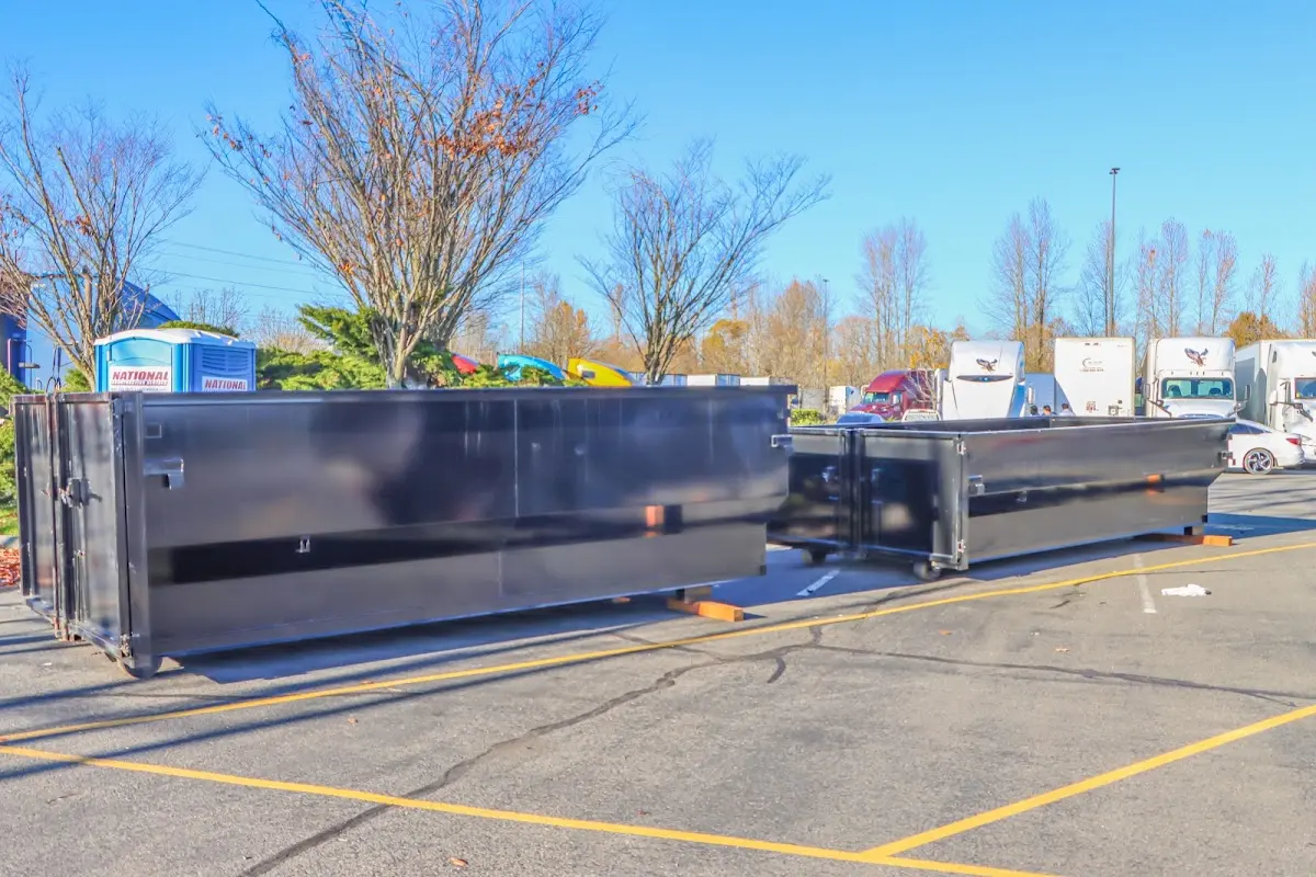 Professional dumpster rental service with roll-off container on residential driveway in West Des Moines